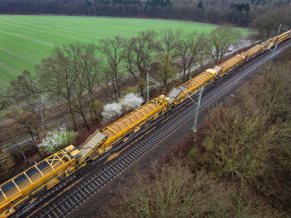 Bettungsreinigung aus der Luft betrachtet. Ein Großteil des Zugs besteht aus den Materialförder- und Silowagen (MFS).