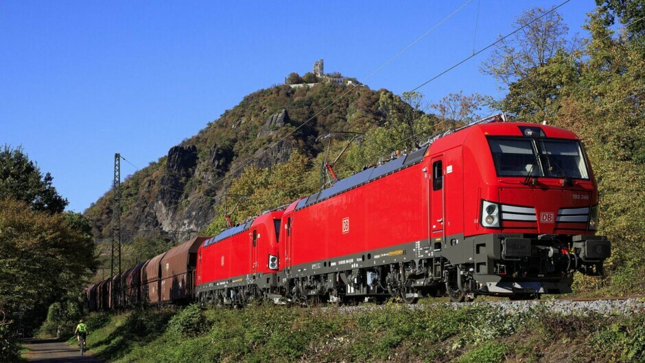 Ein Güterzug fährt unterhalb des Drachenfels bei Königswinter vorbei. 